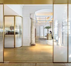 the interior of a modern office building with glass walls and gold trim on the doors