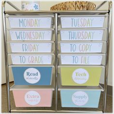 four metal bins with labels on them sitting in front of a wicker basket