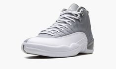 The Air Jordan 12 “Stealth” is a versatile, two-tone grey-and-white colorway of the retro basketball shoe.  Originally released in 1997, the Jordan 12 was worn by Michael Jordan with the Chicago Bulls during the ‘96-97 NBA season, and in the ‘97 NBA Playoffs.  Here, the “Stealth” honors the shoe’s 25th anniversary, and it doesn’t disappoint.  Details include a Stealth Grey tumbled leather upper paired with a white pebbled mudguard.  The color block is reminiscent of the Jordan 12’s “Obsidian” co Jordan 12 Stealth, Gray And White Jordans, Jordan 12s, Retro Basketball Shoes, White Jordans, Retro Basketball, Air Jordan 12, Jumpman Logo, Air Jordan 12 Retro