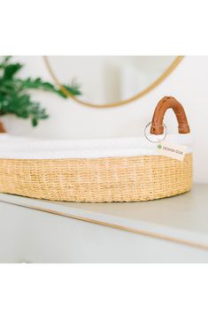 a close up of a baby's bassinet on a shelf with a mirror in the background