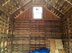 the inside of a wooden building with blue tarp