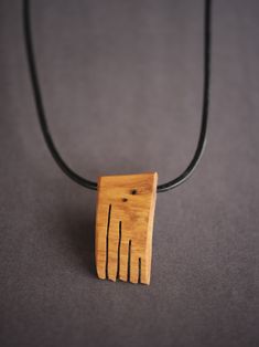 a small wooden piece on a black cord