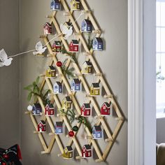 a christmas tree made out of wooden pegs is hanging on the wall next to a window