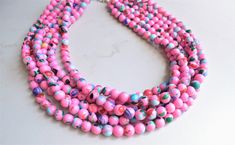 A beaded multi strand statement necklace made with pink beads with colorful chip beads inlaid.- 6 strands - 8mm sized beads- Stainless steel lobster claw clasp (sterling silver is also available)- 18 - 20" shortest strand - 2" stainless steel extender chain- Lead free pewter connectorThe necklace can be lengthened or shortened upon request. The mannequin's neck size is 15". A matching bracelet or earrings can be made.All DLD jewelry comes in a silver jewelry box for gift giving. We use the highe Pink Multi-strand Faceted Bead Necklace, Pink Multi-strand Beaded Necklace With Faceted Beads, Pink Multi-strand Faceted Beaded Necklace, Pink Multi-strand Beaded Necklace, Pink Multi-strand Large Beads, Unique Pink Beads For Jewelry Making, Pink Multi-strand Beads For Jewelry Making, Pink Multi-strand Faceted Beads Jewelry, Pink Multi-strand Jewelry With Faceted Beads