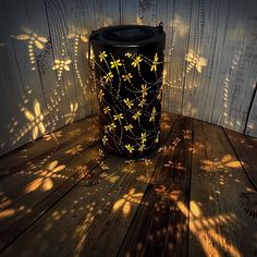 a black trash can sitting on top of a wooden floor