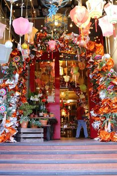 an entrance to a store decorated with paper lanterns and streamers hanging from the ceiling