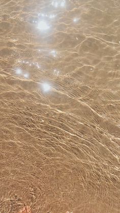 the water is so clear that it appears to be reflecting sunlight on the beach sand