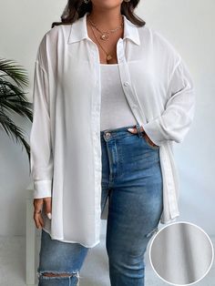 a woman standing in front of a plant wearing jeans and a white shirt with long sleeves