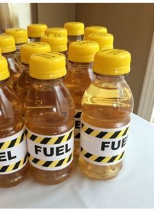 several bottles of fuel sitting on top of a table with caution tape around the lids