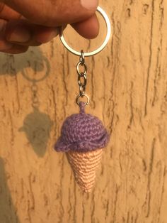 a hand holding a keychain that has an ice cream cone on the end