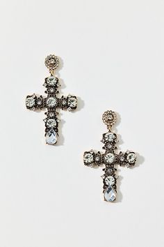 Statement earrings with a dangling drop cross pendant. Complete with a rhinestone finish. Features Nyla rhinestone cross earrings Cross drop earrings Ornate rhinestone finish Post backing Content + Care Mixed metal, glass Avoid contact with water Imported | Nyla Rhinestone Cross Earring in Gold, Women's at Urban Outfitters Cross Earring, Earrings Cross, Rhinestone Cross, Cross Earrings, Mixed Metals, Women Accessories Jewelry, Cute Jewelry, Cross Pendant, Statement Earrings