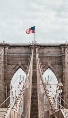 an american flag flying over the brooklyn bridge