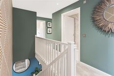 a hallway with green walls and white railings