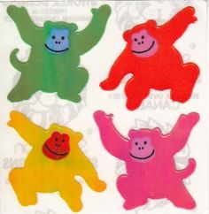 four different colored stickers with smiling faces and hands in the shape of monkeys on them