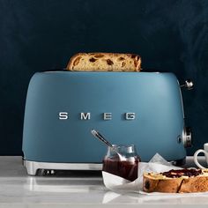 a toaster sitting on top of a counter next to a cup and saucer