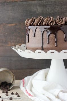 a chocolate cake sitting on top of a white cake plate