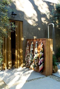 an outdoor shower with towels hanging on it