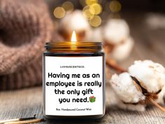 a candle that is sitting on a table with cotton in front of it and the quote having me as an employee is really the only gift you need