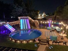 an outdoor swimming pool lit up with lights