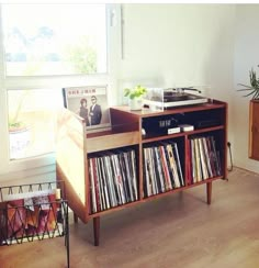 an old record player is sitting on top of a shelf in front of a window