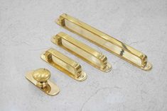 three brass handles and knobs on a marble surface