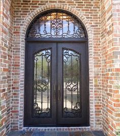 a black double door with glass and wrought iron