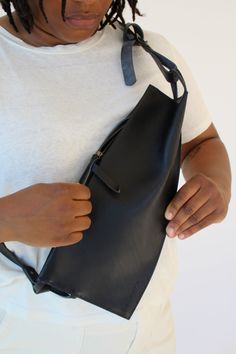 Elevated and functional, the Offset Sling's folded geometric panels add up to an asymmetrical statement piece. Stow a phone, keys, and wallet safely with a concealed zipper that stay close to the chest. The shoulder strap is adjustable with a single Conway-style buckle. This bag fits our Wallet and Cardholder beautifully. Unlined matte leather. Measures 13" wide and 7" deep. 1" wide shoulder strap, adjustable from 20" to 50" long. Sling Bags Women, Diy Clothes Hacks, Clothes Hacks, Sling Bags, Leather Conditioner, Clothing Hacks, Shopper Bag, Handle Bag, Vegetable Tanned Leather