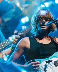 a woman playing an electric guitar on stage