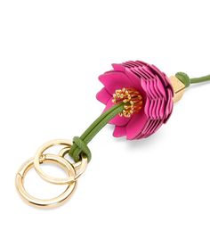 a pink flower with two gold rings attached to it