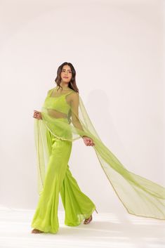 Featuring a neon green glass neck blouse in georgette base. It is paired with a solid crepe matching flared sharara pants having embroidered waist band and net dupatta with lace edging. Color: GREEN FABRIC: GORGETTE Delivery time 15 to 20 days Floor-length Pista Green Georgette Palazzo Set, Green Floor-length Sets With Sheer Dupatta, Green Designer Pant Set For Diwali, Anarkali Style Green Pant Set For Designer Wear, Green Fitted Designer Pant Set, Green Pant Set With Dupatta For Eid, Fitted Green Georgette Palazzo Set, Bollywood Style Green Palazzo Set With Sheer Dupatta, Green Georgette Anarkali Set With Unstitched Blouse