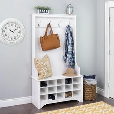 a white coat rack sitting next to a clock