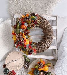 a white chair sitting next to a wreath and other decorations on top of a table