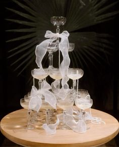 a sculpture made out of wine glasses on top of a wooden table