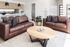 a living room with couches, chairs and a table in front of a kitchen