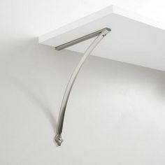 the corner of a white wall with a metal hook on it