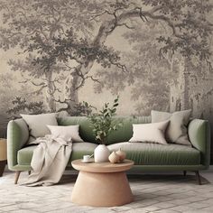 a green couch sitting in front of a tree mural