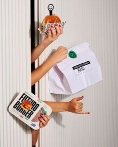 two women holding up paper bags with food on them