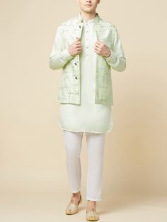 This Mint Green Kurta Bundi Jacket Set will instantly give an elegant look. This 3 piece kurta bundi set features a mint green mirror embroidered bundi jacket with a mint green kurta, front button placket, and a mandarin collar. It is paired with white churidar pants. An ideal outfit for traditional occasions, and special events.

Size Chart For Men





	
	
					Men's Size Chart
		

		
		
						
				Size Chart For Men
				Custom Size Measurement Guide
			
			
				
				
				Custom Size Measureme Designer Sherwani For Spring, Pista Green Resham Embroidered Kurta For Spring, Fitted Bandhgala Straight Kurta For Spring, Spring Cotton Nehru Jacket With Zari Work, Straight Kurta Nehru Jacket With Zari Work For Spring, Pista Green Kurta With Resham Embroidery For Spring, Designer Green Kurta For Spring, Spring Pista Green Kurta With Resham Embroidery, Spring Nehru Jacket With Zari Work, Straight Kurta Style