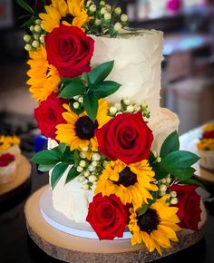 a wedding cake decorated with sunflowers and roses