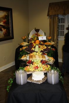 a table topped with lots of different types of food on top of a black cloth