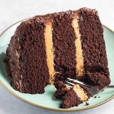 a piece of chocolate cake on a blue plate with a fork in it and one slice missing