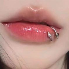 a woman's lips with two piercings on them, and the bottom part of her lip