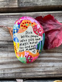 a painted rock sitting on top of a wooden bench