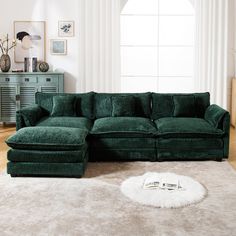 a large green couch sitting on top of a white rug in a living room next to a window