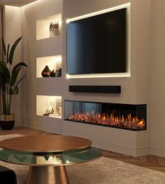 a living room with a large television mounted on the wall and a fire place in front of it