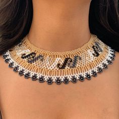 a close up of a woman wearing a necklace with the word bead on it