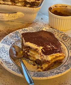 a piece of cake sitting on top of a plate next to a bowl of pudding