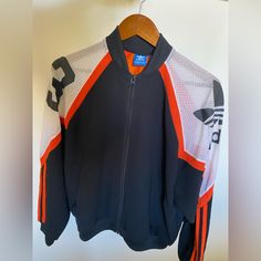 Brand New Trendy Zip Up Adidas Black Track Jacket For Spring, Spring Adidas Black Track Jacket, Retro Black Track Jacket For Spring, Casual Orange Track Jacket For Winter, Retro Black Track Jacket For Fall, Orange Outerwear For Sports In Fall, Long Sleeve Orange Track Jacket For Fall, Orange Long Sleeve Track Jacket For Fall, Orange Track Jacket For Fall Streetwear