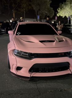 a pink car parked on the street at night