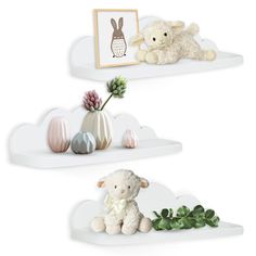 two white shelves with stuffed animals and flowers on them in the shape of sheeps